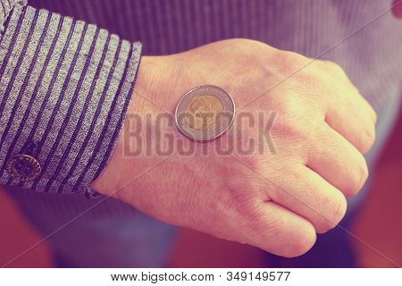The Spanish Coin Lies On A Male Hand. The Game 