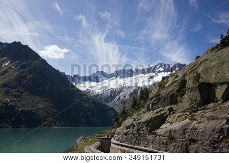 Lake On The Goescheneralp With Snow Covered Mountains In The Background