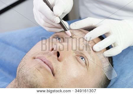 Young Man Microblading Procedure To Improve The Condition Of A Mans Eyebrows In A Beauty Salon.