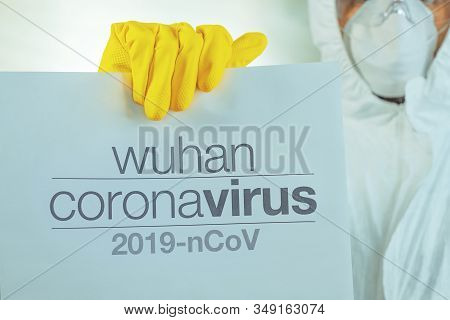 Wuhan Coronavirus Warning Paper Banner Held By Male Epidemiologist In Protective Clothing