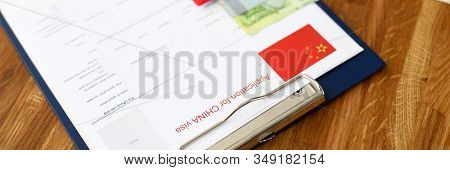 Red Passport Lie Against China Application Form Backgroung Cloceup.