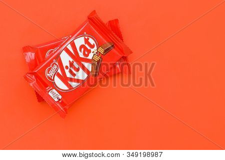 Kit Kat Chocolate Bar In Red Wrapping Lies On Red Background. Kit Kat Created By Rowntrees Of York I