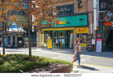Seoul, March - 2019: House with shops and cafes, a woman walks along the street. Old city street.
