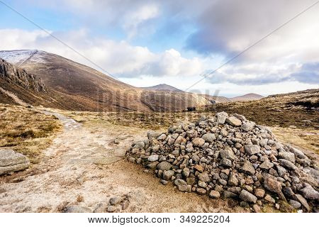 Footpath Leading To Snow Capped Peak Of Slieve Donard Mountain. Pile Of Stones In Mourn Mountains, M