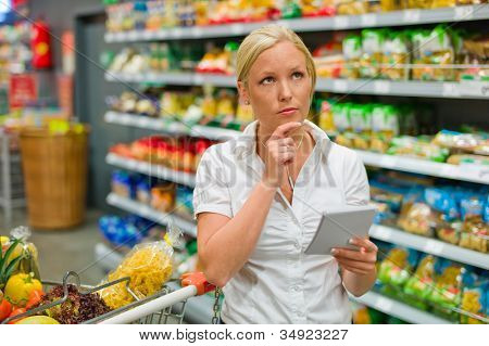 una donna è sopraffatto dalla selezione enorme quando lo shopping in un supermercato.