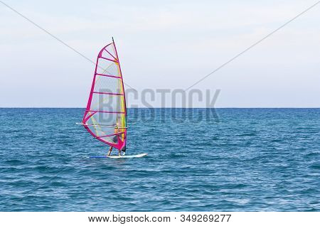Pink Windsurfing Sail On The Background Of The Azure Sea