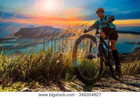 Cycling woman on electric bikes. MTB enduro trail track. Outdoor sport activity.