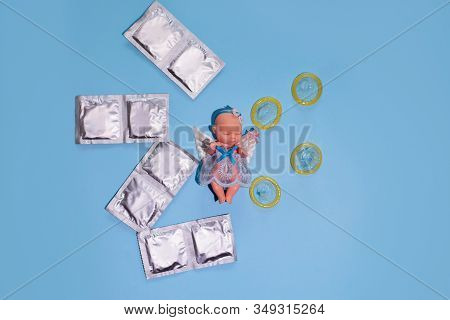 Group Of A Condom On A Blue Background, Closed And Open, Layout With A Baby Doll, Flat Lay
