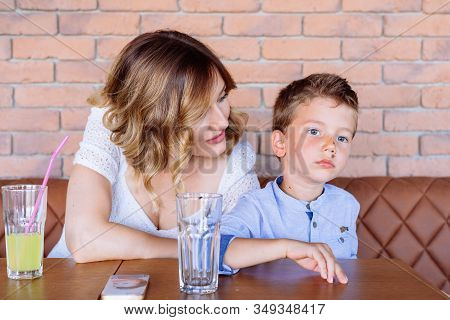 Mom Is Looking At Son, Telling Him Something, He Looks Like He Doesn Not Care. Human Facial Expressi