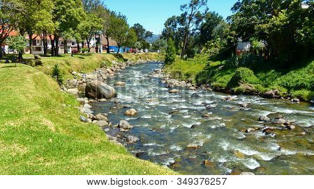 Cuenca, Ecuador.  View Of The River Tomebamba And Public Park Along The River That Crosses The Cente