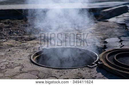 Steam, Smoke, And Gas Flow From The Open Hatch On The Street.