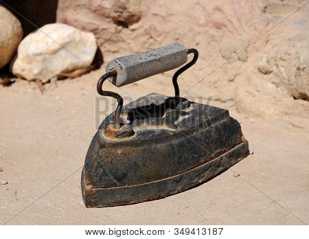 Antique Black Rusty Iron On A Yellow Stone