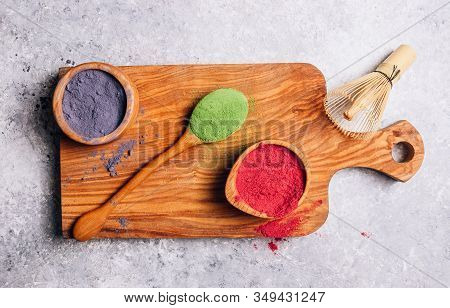 Different Colors Of Japanese Matcha Tea: Green, Red And Blue In Wooden Bowls On Gray Background. Aca