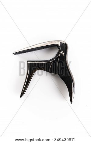 A Capotasto Isolated On A White Background, Top View. Guitar Equipment, Musical Special Effects. Cap