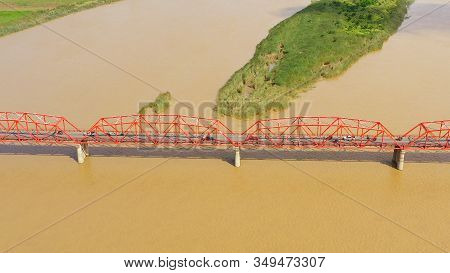 Cars Ride On The Bridge. Wide River On The Island Of Luzon, Philippines, Aerial View. Bridge Over Th