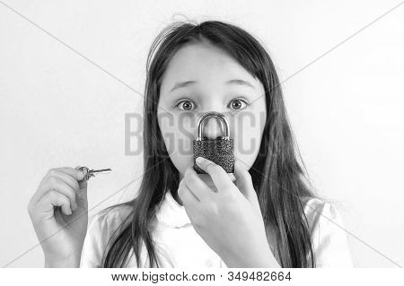 Conceptual Portrait Of A Child Keeping Silence With Lock Over Her Mouth And A Key To The Lock In You