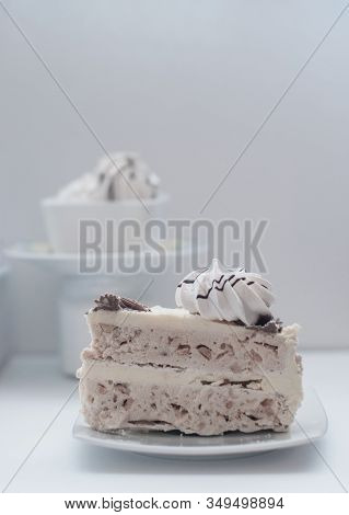 White Cake With Merinques And Cream On The Table