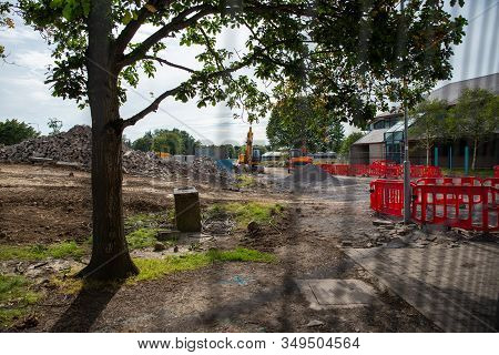Fenced Construction Site. A Beautiful Gives Stark Contrast To The Machine And Rubble In The Backgrou