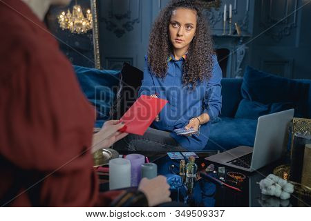 Calm Soothsayer Sitting In Front Of Her Client