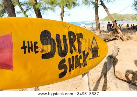 Yellow Surfboard Sign Leading To The Surf Shack
