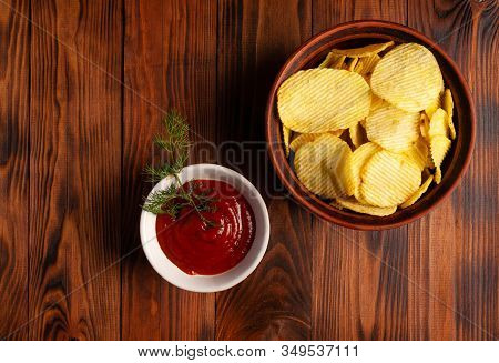 Wavy, Potato Chips In A Plate With Ketchup On A Wooden Table. Top View Of Snacks. Stock Photo Potato