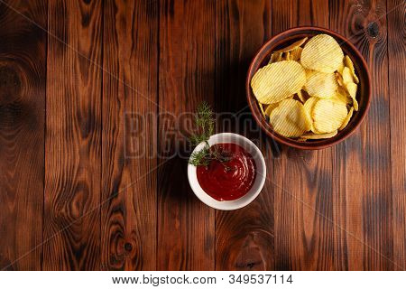 Wavy, Potato Chips In A Plate With Ketchup On A Wooden Table. Top View Of Snacks. Stock Photo Potato