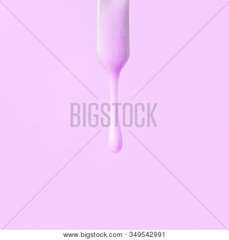 Liquid Pink Wax Or Sugar Paste For Depilation Drains From The Stick On Pink Background. The Concept 