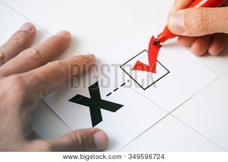 closeup of a young caucasian person doing a check mark on a paper with a X written in it, for the third gender category