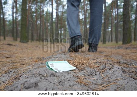 Young Man Loses His Euro Money Bills On Russian Autumn Fir Wood Path. Carelessness And Losing Money 