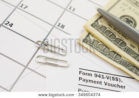 Irs Form 941-v Payment Voucher Blank Lies With Pen And Many Hundred Dollar Bills On Calendar Page