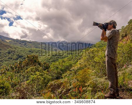 A Photographer Taking Pictures Of Birds From The Edge Of Mountain At The Paramo Chontales In The Cen