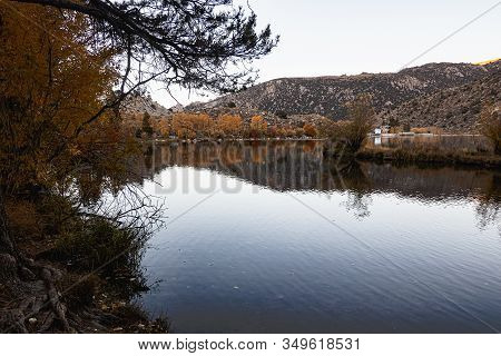 Large Lake Reflecting Autumn Trees Colors And The Mountain