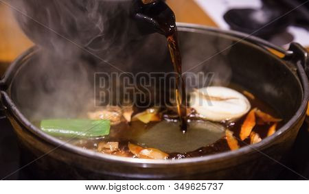 Selective Focused Pot Pouring Soup On Japanese Nabemono Hotpot Dish Of Thinly Sliced Meat Boiled In 