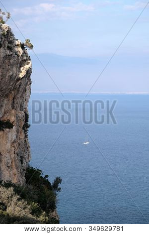 High Impregnable Cliff With Poor Mountain Vegetation On Top And Calm Sea Far And Down And Turkish An