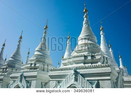 White pagodas of Sanda Muni Paya Buddhist stupa in Mandalay, Myanmar
