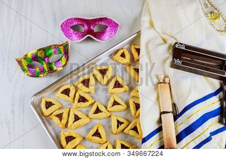Jewish Cookies With Jam For Purim With Mask, Tallit And Noisemaker With Tora.