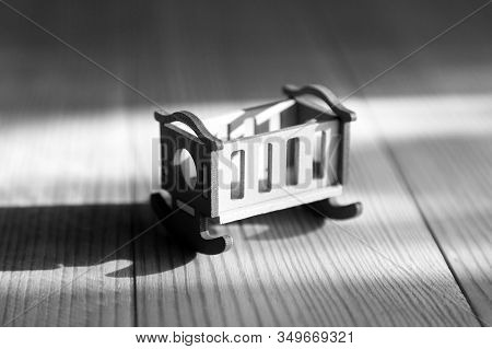 Empty Crib On A Wooden Background Infertility Concept, Lack Of Children In The Family, Empty Crib