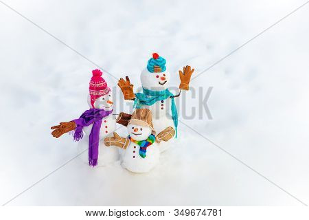 New Year Banner. Funny Group Of Snowmen Family In Stylish Hat And Scarf On Snowy Field. New Year Gre