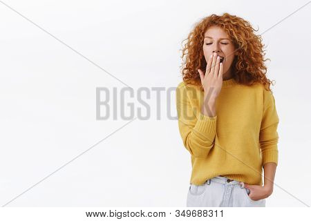Attrative Modern Young Curly-haired Redhead Woman Standing In Office, Making Morning Coffee, Wearing