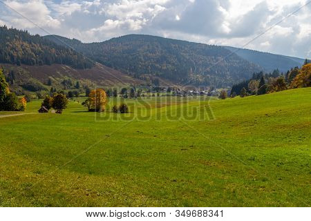 Landscape With Green Meadow, Multi Colored Trees, Mountain Range With Forest Nearby Menzenschwand, B