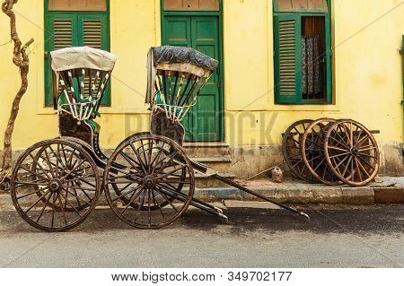 Hand Pulled Rickshaws Are Parkedon The Street In Kolkata. India