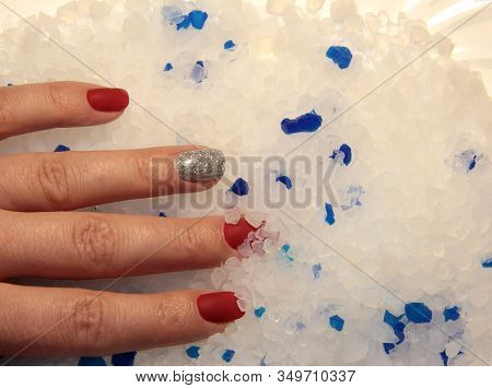 White And Blue Stones. A Woman\'s Hand On Silicone Crystals.