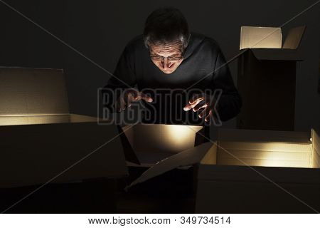 Mature Greedy Man Opening Parcels With Ligthts Inside
