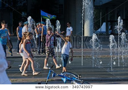 Children Play Near The Fountain On The Background Of Demobilized Paratroopers, During The Holiday Of
