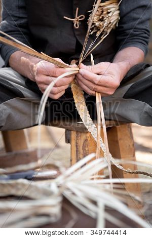 Wicker Craftsman Working With His Hands In The Manufacture Of A Basket