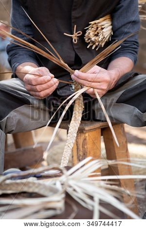 Wicker Craftsman Working With His Hands In The Manufacture Of A Basket