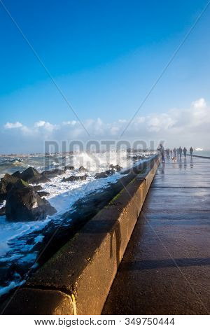 Pier At Corner Of Holland, With Basalt Blocks And Splashing And Foamy North Sea Water In The Winter 