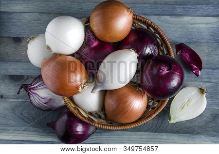 Large Bulbs Of Yellow, Red And White Onions Close-up In A Wicker Basket