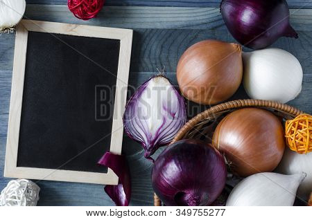 Red, White, And Beige Onions On A Blue Background Dark-colored Placard For Text