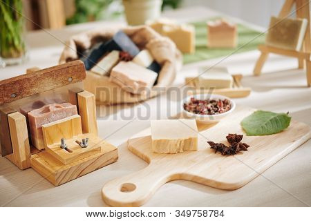 Dried Rose Buds, Leaves And Badian Flowers For Making Soap Bars On Table In Workshop